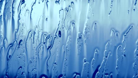 cold rain pouring on glass close up