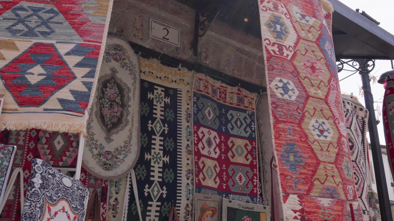 Geleneksel Arnavut halıları, karmaşık geometrik dokuma desenleri ve canlı renkler sergiliyor.