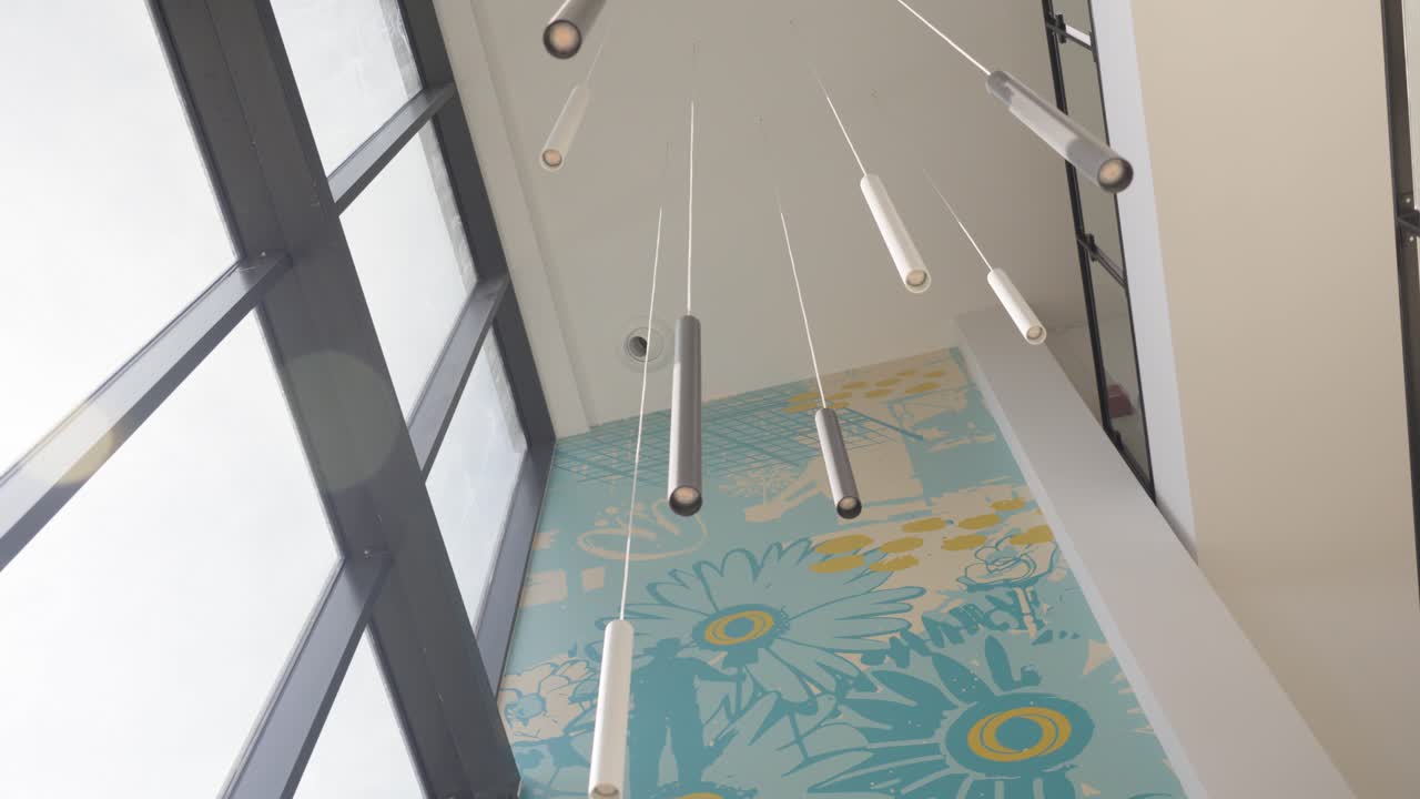 Ripresa lenta in orbita di un grande lampadario appeso all'interno di un ufficio.