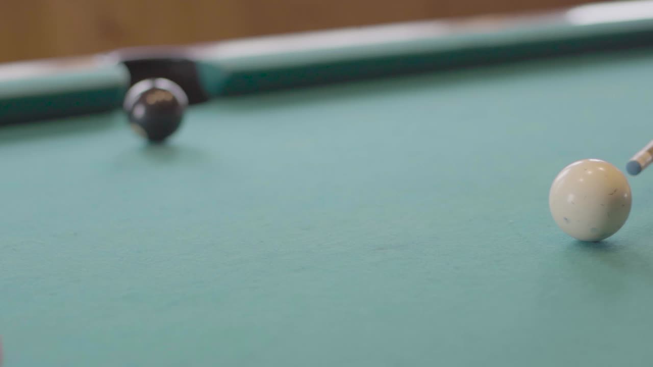 Aiming at white ball on green pool table. Hand held shot