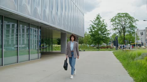 businesswoman walking outside modern office building