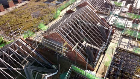 unfinished timber rooftop scaffolding framework on townhouse property development site, aerial view