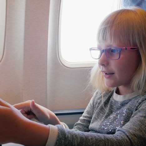 a 6 year old girl is flying in an airplane