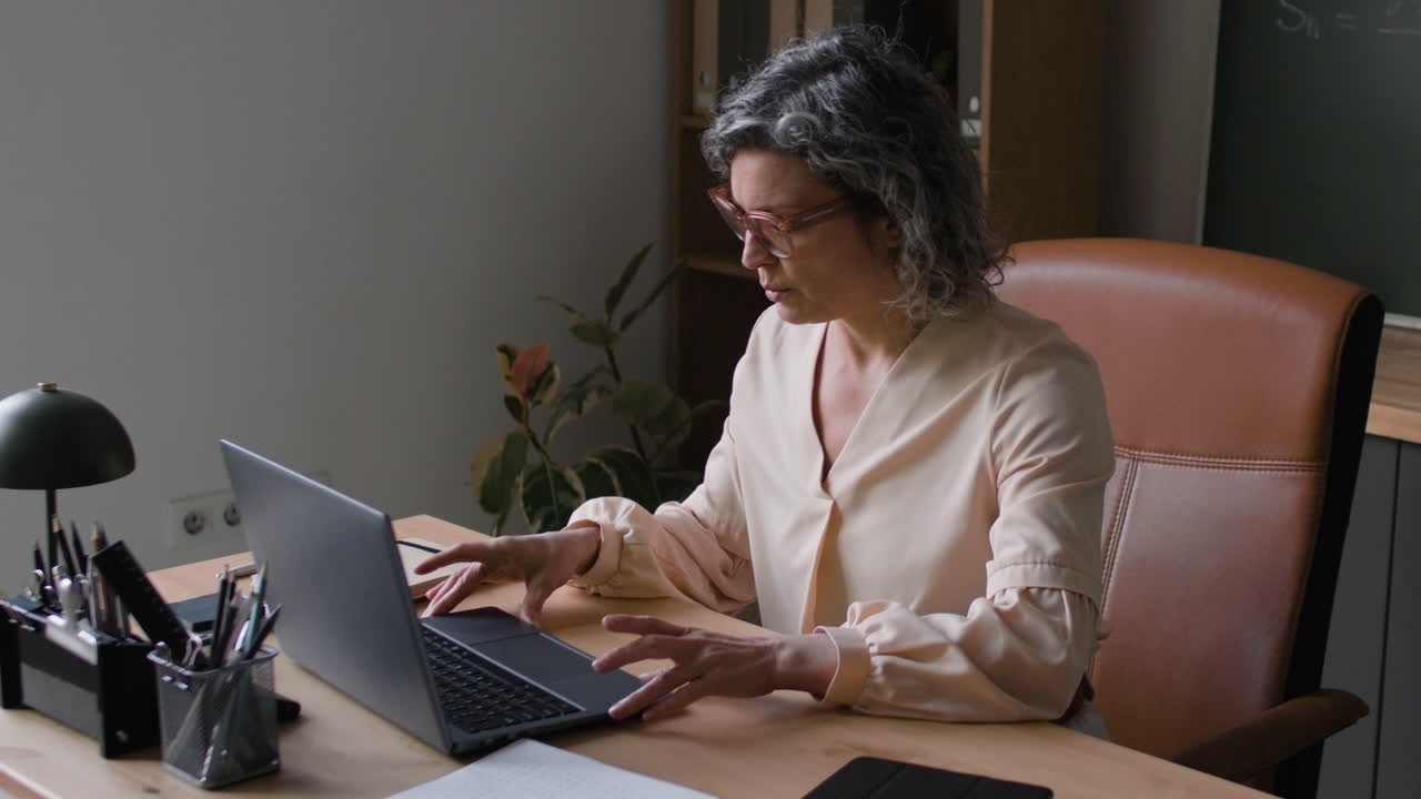 mujer trabajando en una computadora portátil en la oficina del hogar