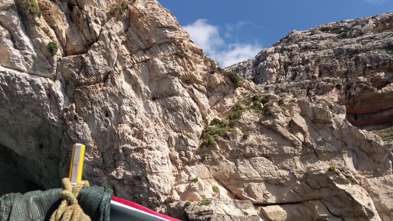 vista desde el tradicional barco de pesca luzzu acercándose a las cuevas de la costa rocosa de la gruta azul en malta en un día soleado de verano