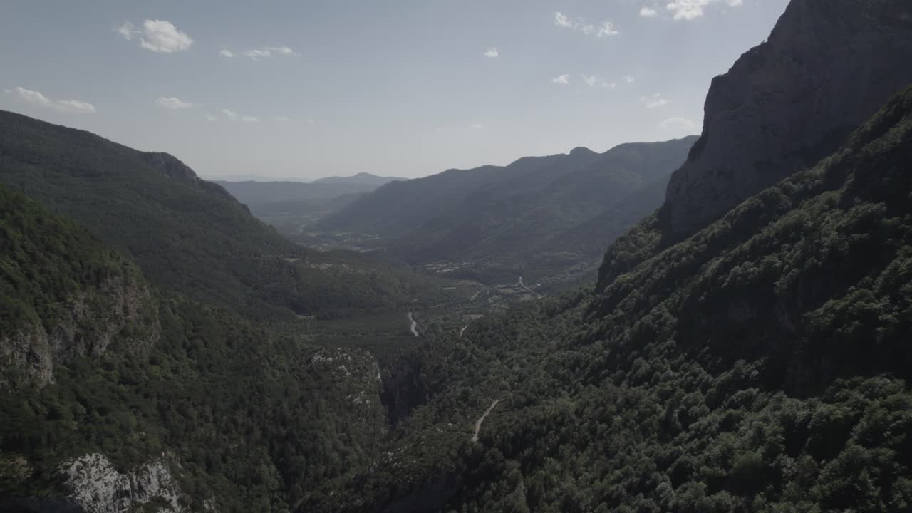This drone video showcases a stunning frontal descriptive shot flying over the Boca del Infierno Gorge road in the Western Valleys Natural Park, Huesca, Spain, amid breathtaking mountain scenery.