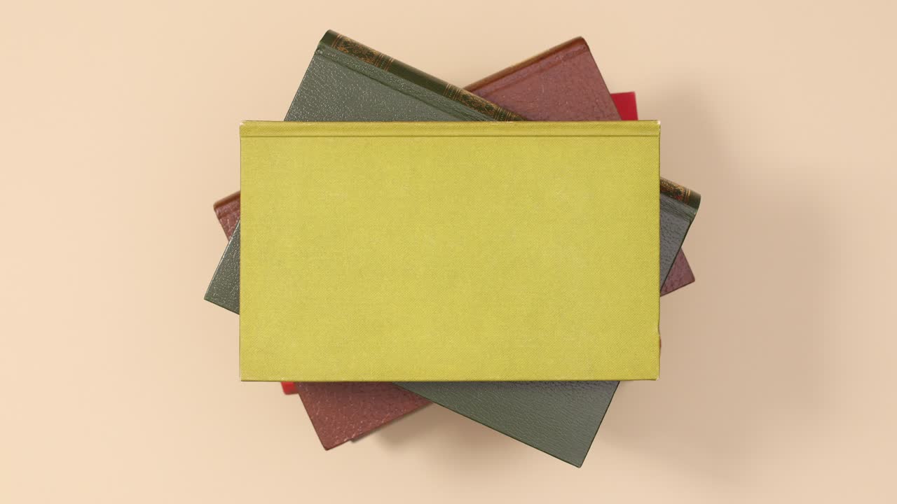 Pile of hardcover vintage books ordering one on the other on beige background. Stop motion flat lay