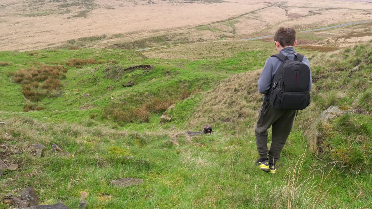 습지 에서 야외 에서 어린 소년 이 그의 rc 자동차, 트럭, 4 x 4 와 함께 놀고 있다