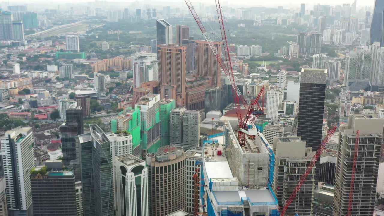 vuela por el centro de kuala lumpur, capturando el paisaje urbano con un denso paisaje urbano lleno de edificios comerciales de gran altura y apartamentos residenciales con estructuras en construcción
