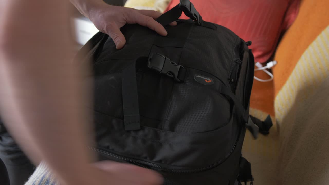 무거운 카메라 가방을 싸서 지퍼를 잠그고 촬영 준비