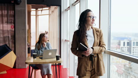 tired business lady standing at the window. busy office worker forgot about something. blonde lady working at backdrop.