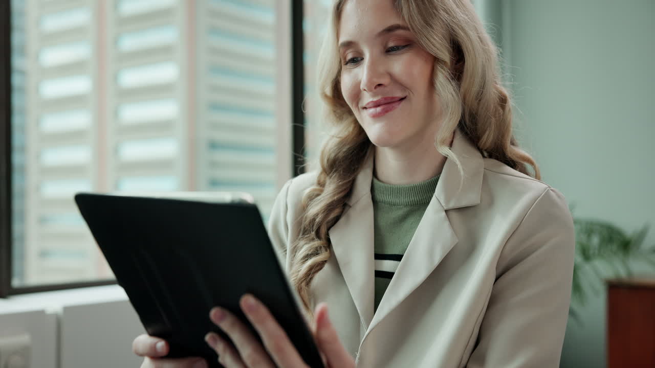 бизнесменка, использующая планшет в офисе