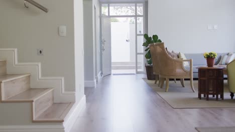 furniture in living room, and hallway with stairs in white modern house