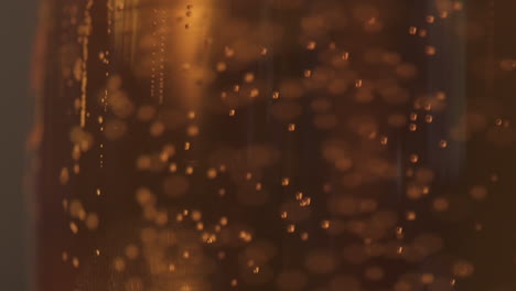 close up macro shot bubbles rising slowly in pint of beer
