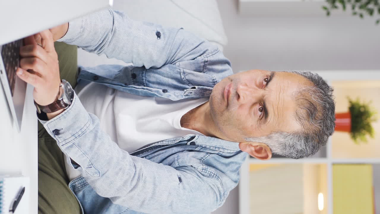 el video vertical del hombre mirando la computadora portátil es reflexivo.