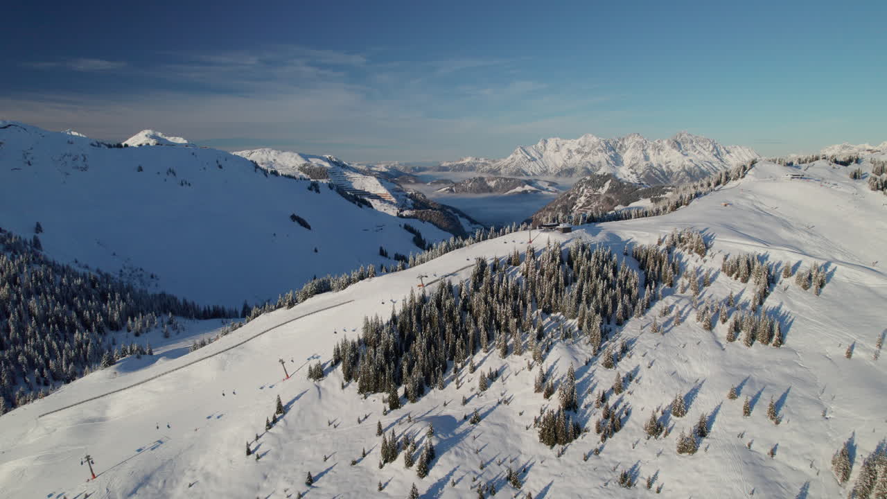Skilift in der Ferienregion Saalbach-Hinterglemm mit den Bergen Kleines Rothorn und Matterhorn im Hintergrund, Österreich.