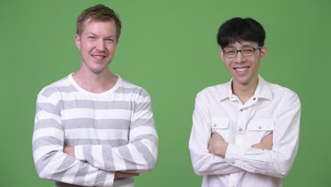 two happy young multi-ethnic businessmen together with arms crossed