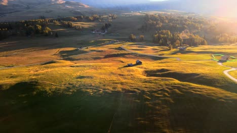 montagnes, forêts et champs d'herbe avec des cabanes en bois filmées à l'alpe di siusi alpes européennes, dolomites italiennes filmées dans des couleurs vibrantes au coucher du soleil