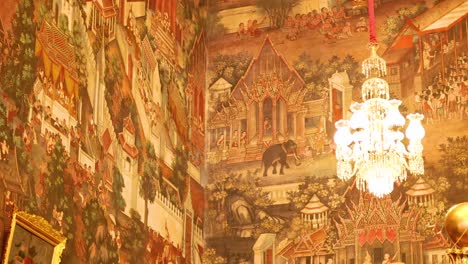 Golden Buddha statue in Wat Arun temple, Bangkok. Intricate murals, warm lighting, and ornate chandeliers create a serene atmosphere