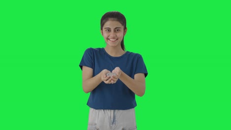 Happy-Indian-teenage-girl-holding-lot-of-coins-Green-screen