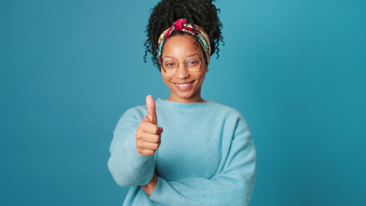 Giovane donna afroamericana che sorride e fa il pollice in su.