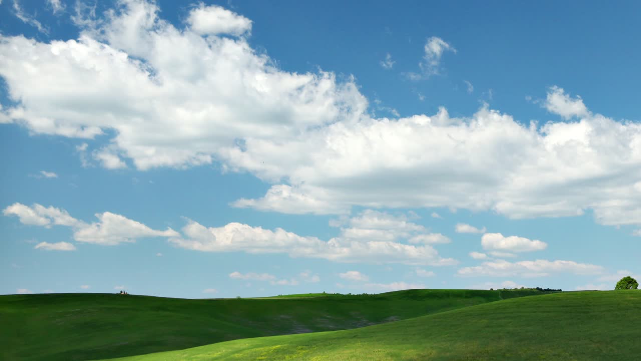 Blue sky, white clouds, green fields - 4k time-lapse from Tuscany, Italy