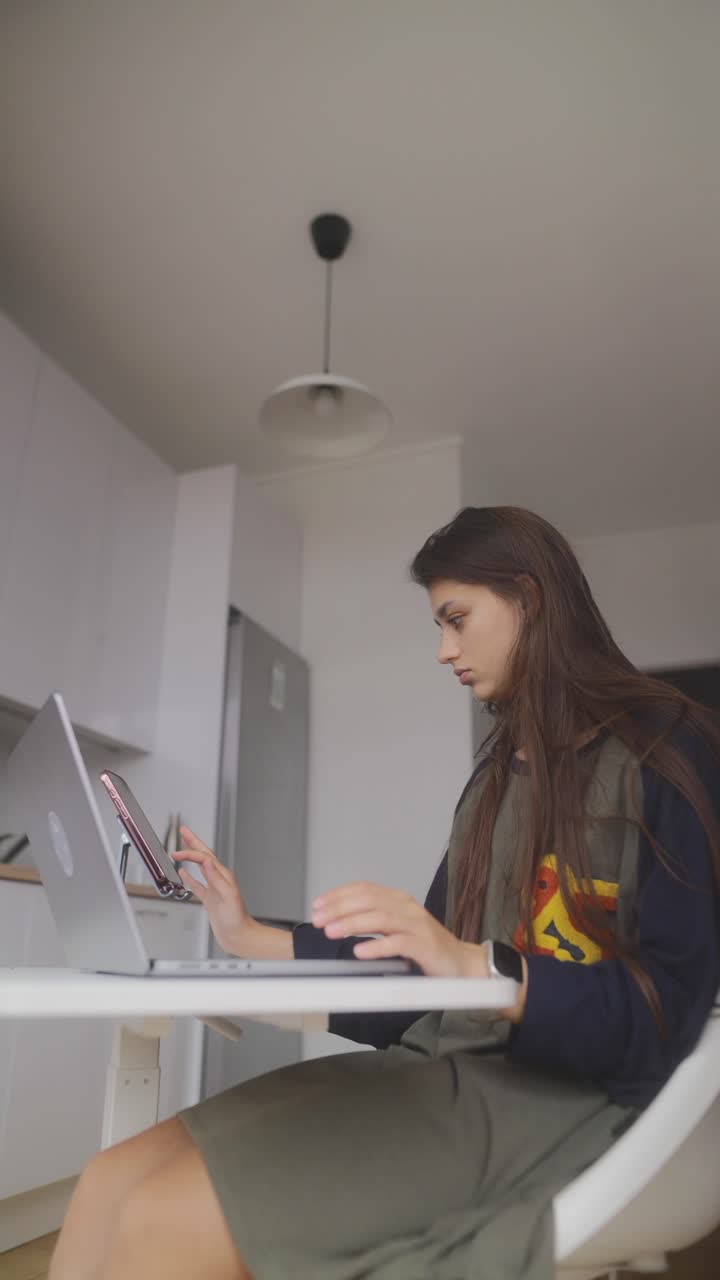 Young woman working from home on a laptop and tablet
