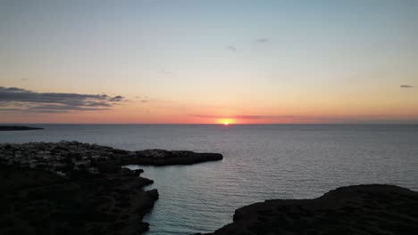 breathtaking sight of sun rising on the horizon from cala petita island in mallorca, spain