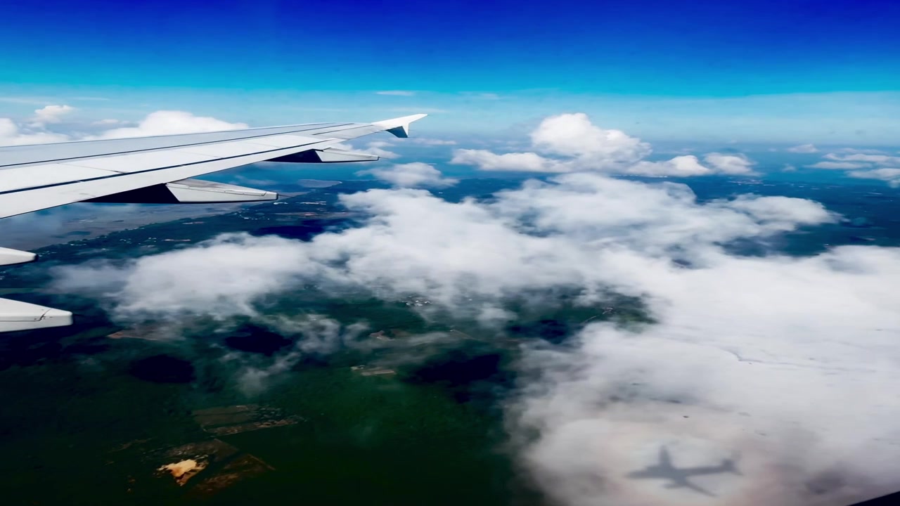 Luftudsigt fra flyvindue over skyer og landskab