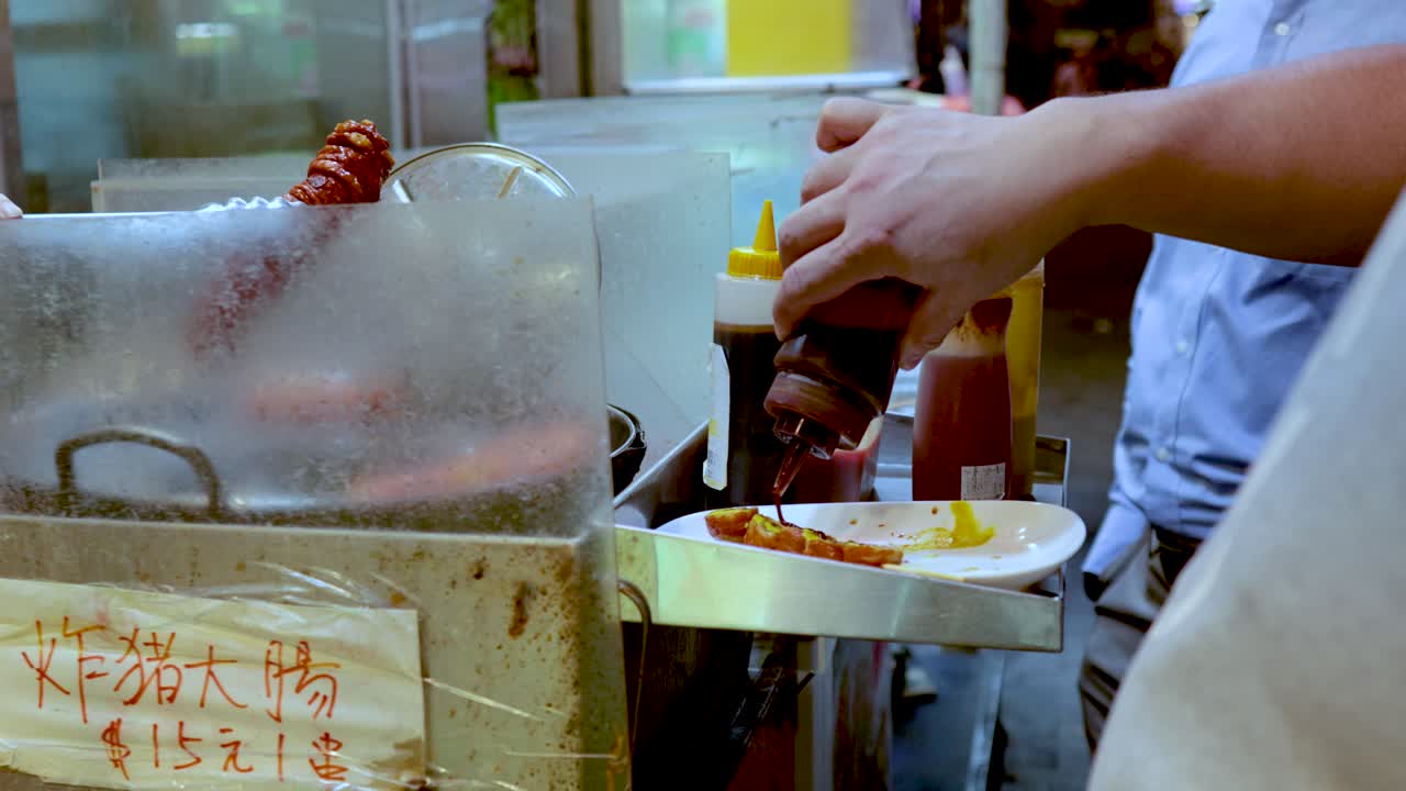 Vendor adds sauce to grilled meat sticks