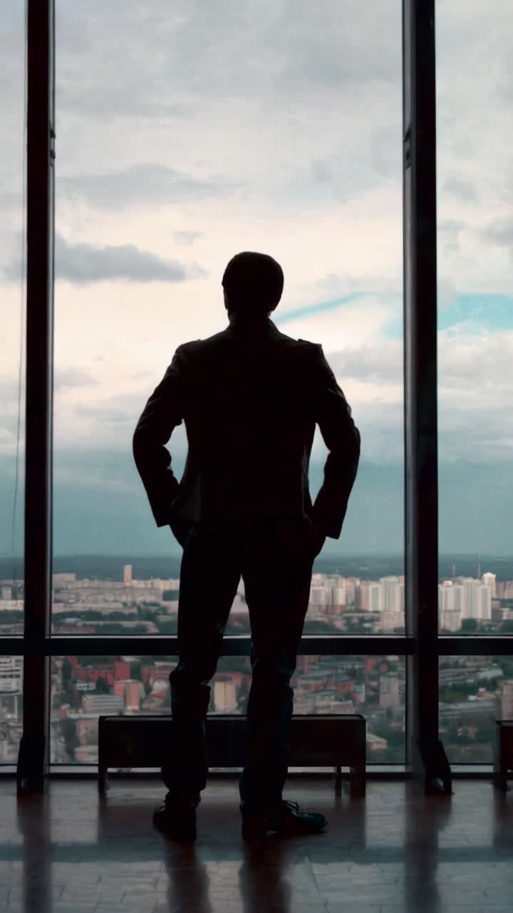 Businessman Looking at City View from High Rise Window