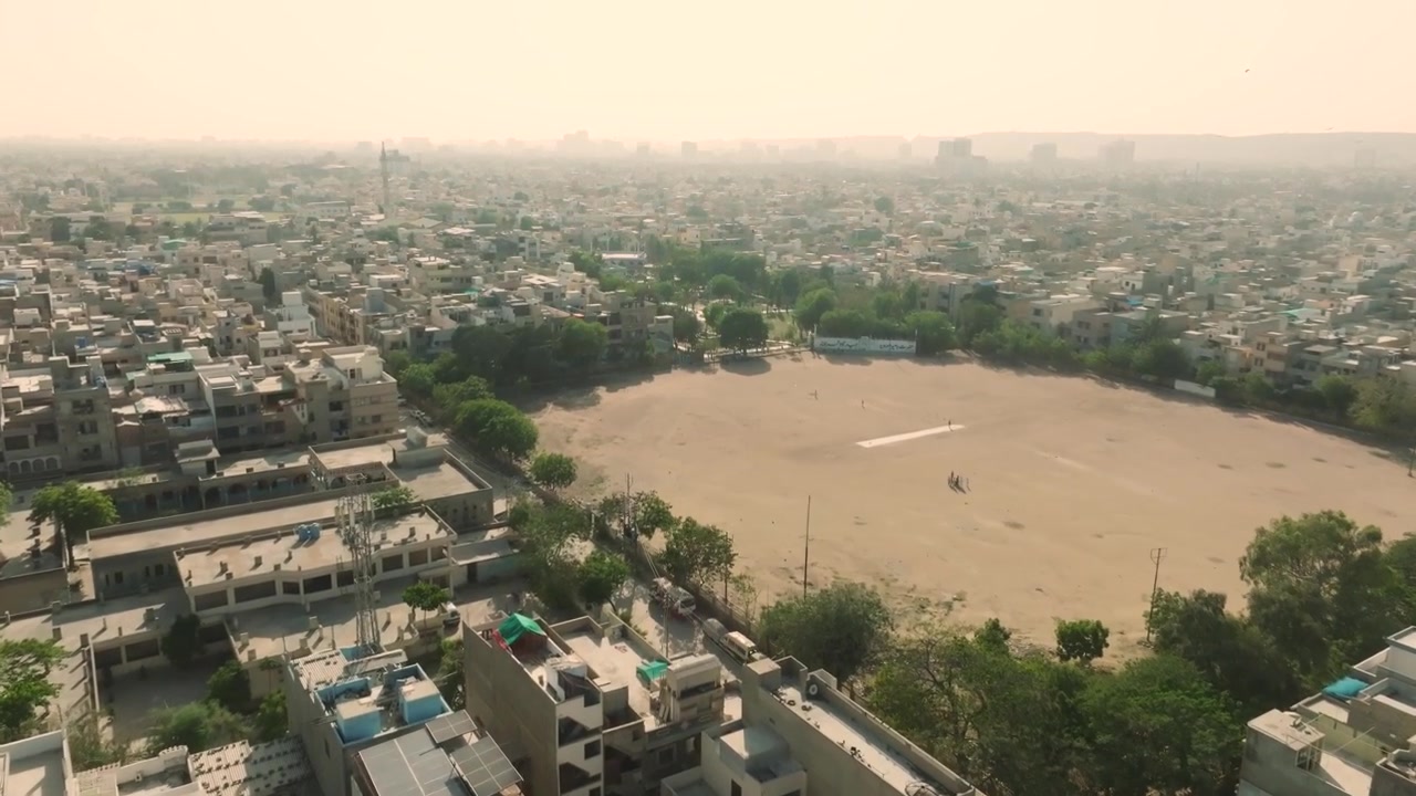 Ancholi, Karachi, Pakistan: Ripresa aerea con drone in movimento in avanti sopra la città di Ancholi, Karachi, Pakistan in una giornata di sole. Parco giochi.
