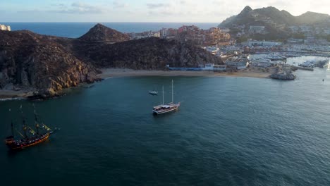 barco privado en medio del mar, con la luz del atardecer, con formaciones rocosas al fondo