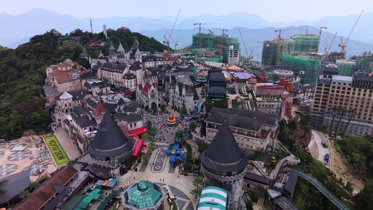 Un filmato aereo con drone cattura il vasto complesso di divertimenti Ba Na Hills SunWorld con architettura castellana, montagne circostanti e costruzioni in corso in Vietnam.