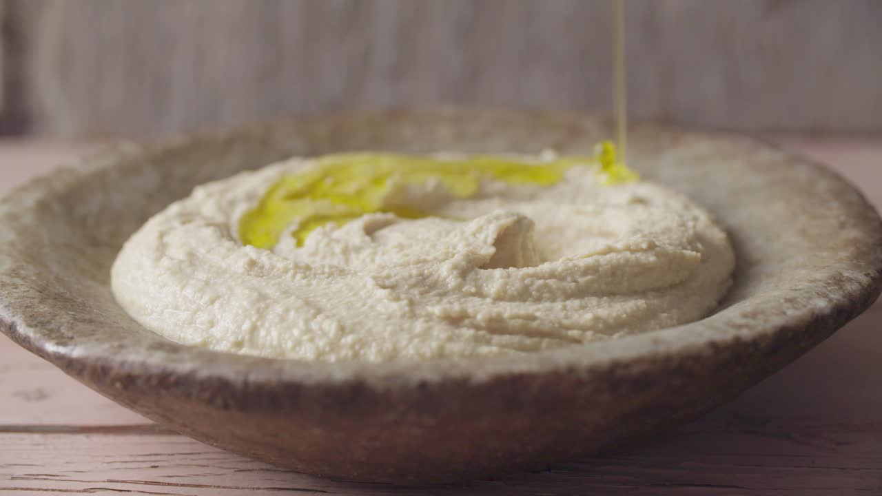 aceite de oliva que cae en el hummus