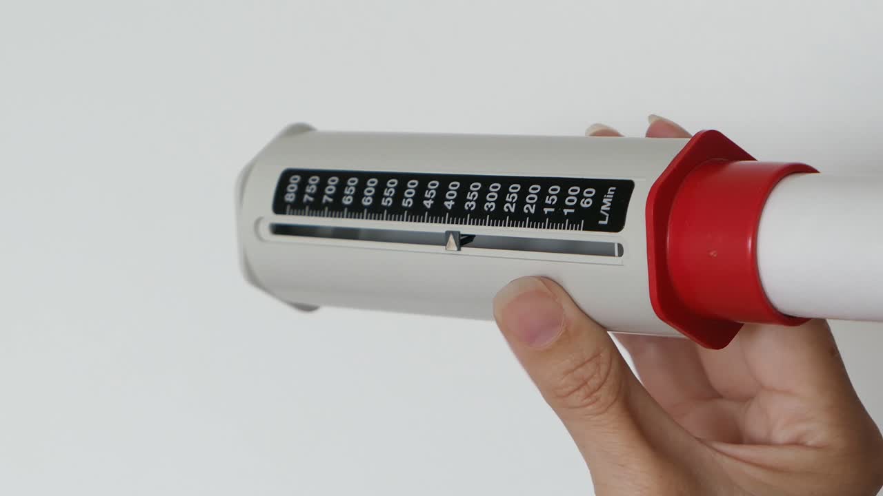 женщина, использующая тест на астму pef для измерения пикового экспирационного потока для легких