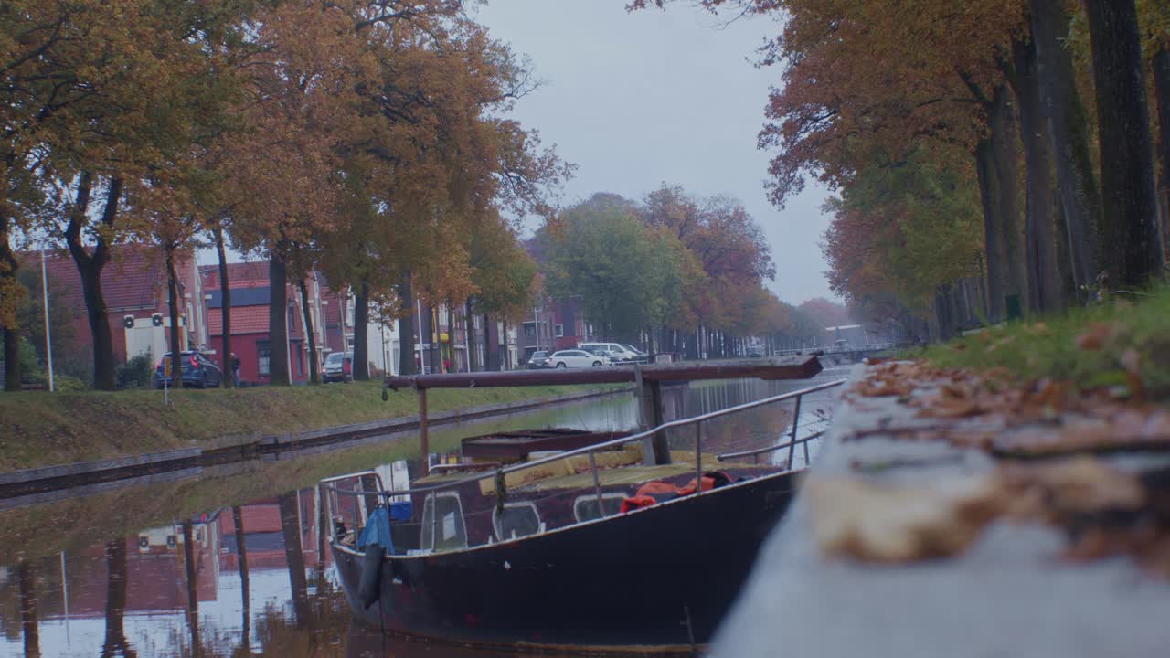 네덜란드의 마을에서 물과 보트 가을 가을에 집과 나무와 잎과 함께 조용한 거리 길 에
