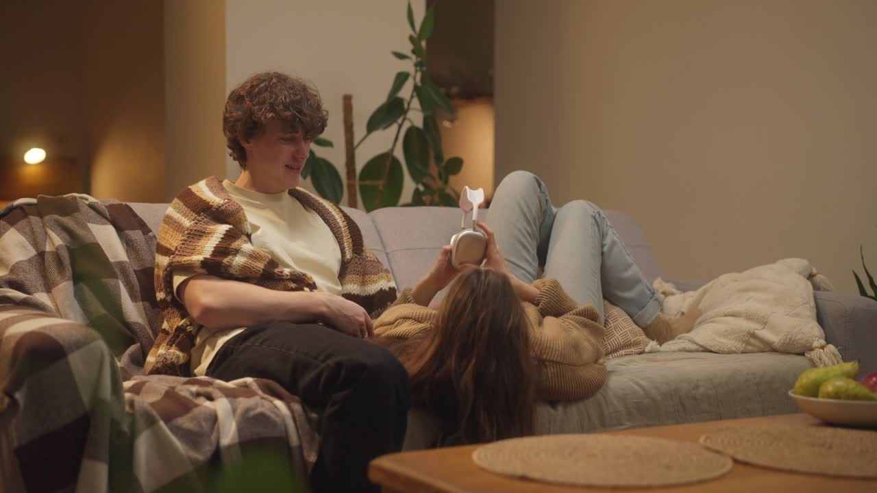 Couple relaxing on couch with headphones
