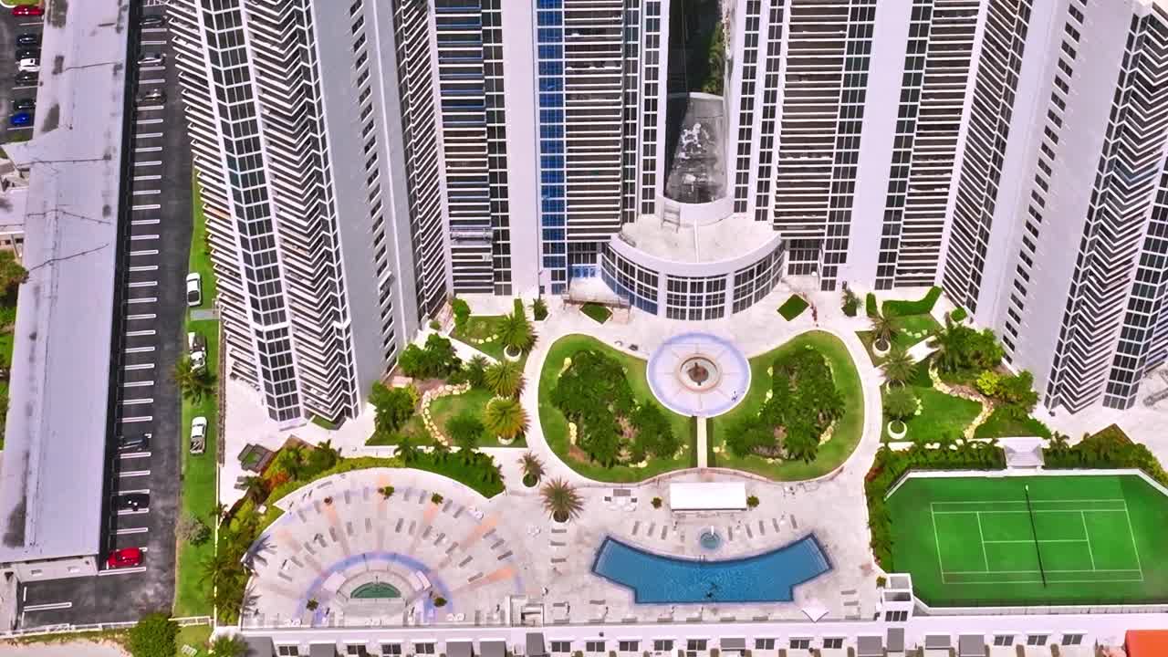 Veduta aerea di un resort di Miami con piscine e campi da tennis sotto il sole