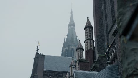 slowmotion shot of a church steeple being covered by the incoming fog in rotterdam