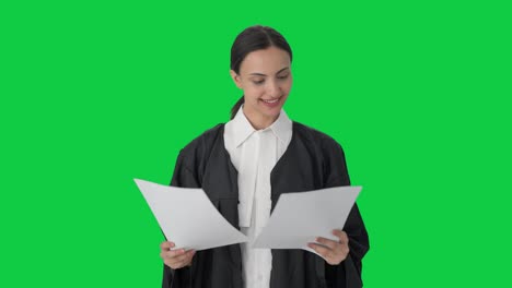 feliz abogada india leyendo archivos de casos pantalla verde