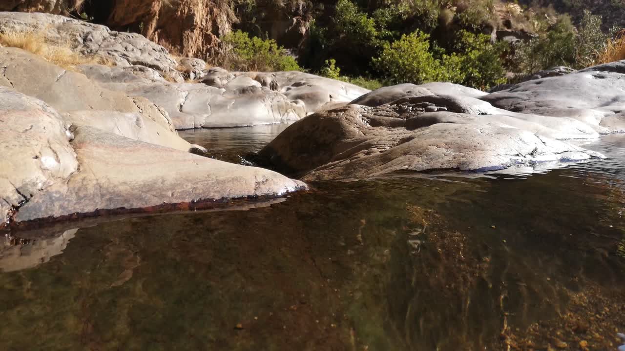 Closeup of water flowing out of a rock pool in the desert