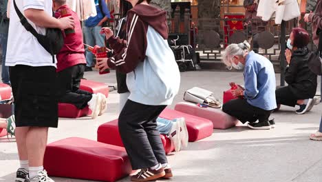 people kneeling and praying with red cushions