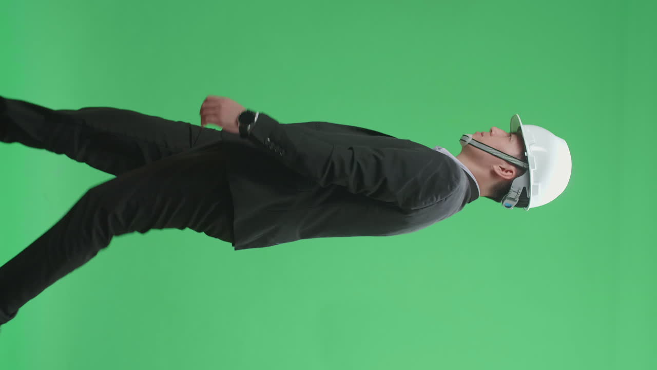 Businessman in construction helmet walking on green screen