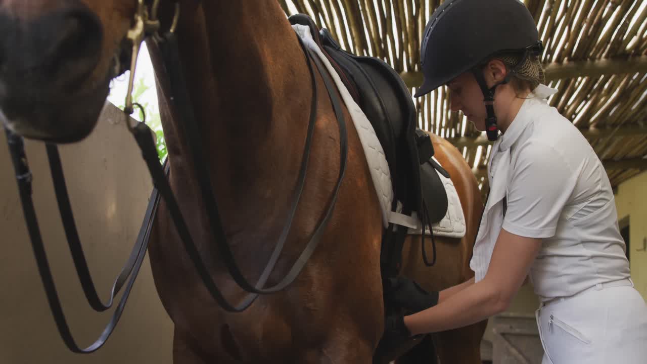 mujer caucásica preparando el caballo de doma