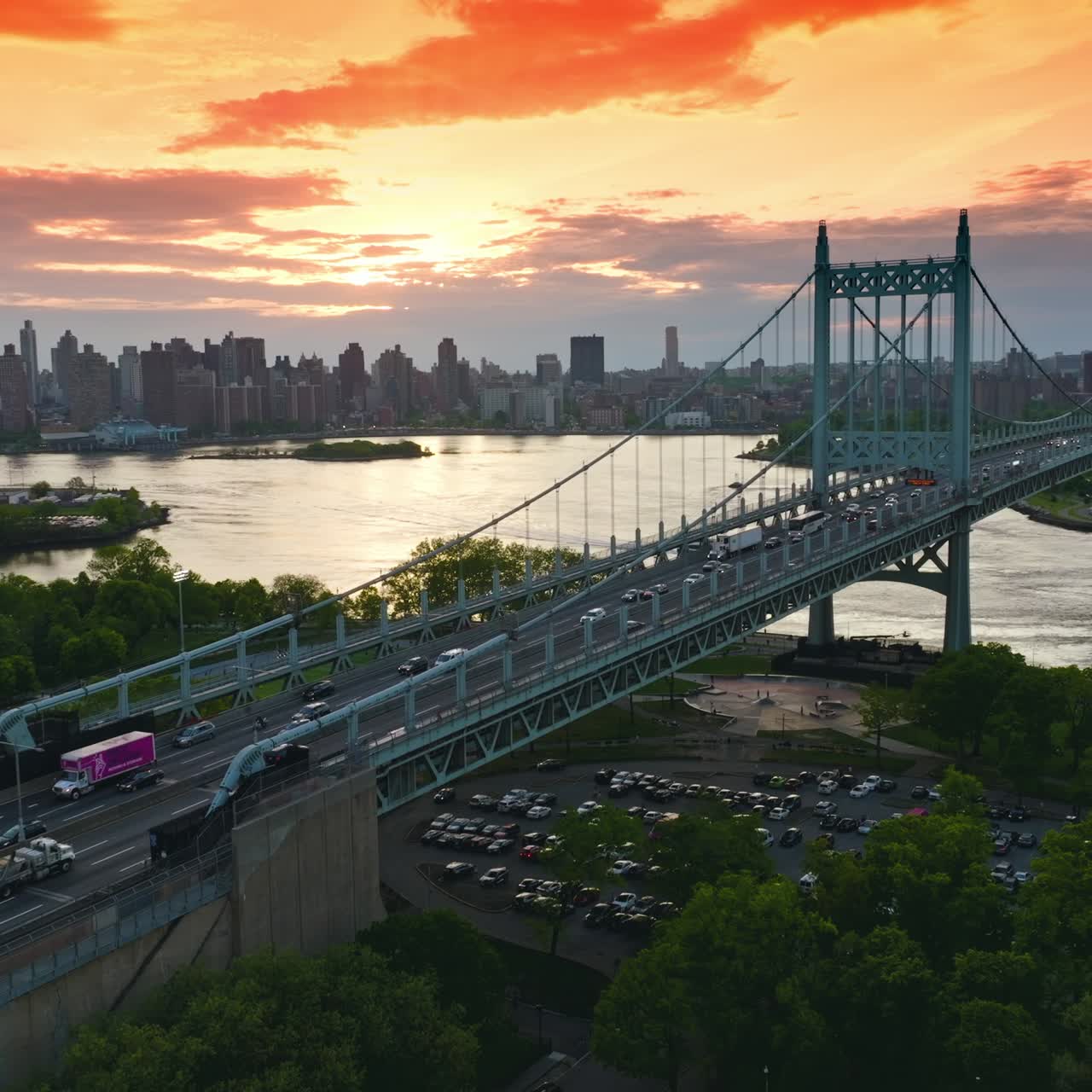 Marvelous bridge connecting green banks of the river. Busy traffic along the bridge. Megapolis skyline at backdrop