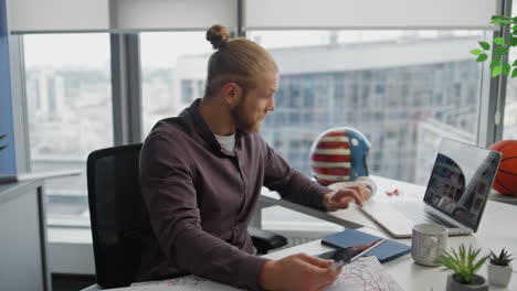 Seriöser-Entwickler-Beobachtet-Laptop-Im-Büro-Aus-Nächster-Nähe.-Mann-Benutzt-Tablet-Computer