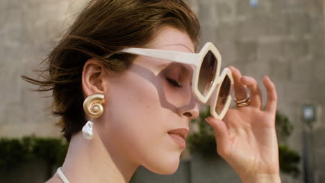 Close-up-view-of-elegant-woman-putting-the-sunglases-on