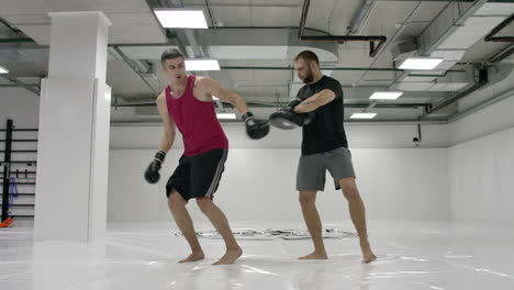 El-Entrenador-Y-Los-Kick-boxers-Practican-Patadas-En-El-Salto-Con-Rotación-De-Las-Patas-En-Cámara-Lenta.