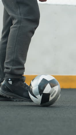 pies de atleta hábilmente maniobrar la pelota de fútbol durante la sesión de entrenamiento en la cancha deportiva al aire libre, precisión, características de fondo pared de hormigón y línea de borde amarillo